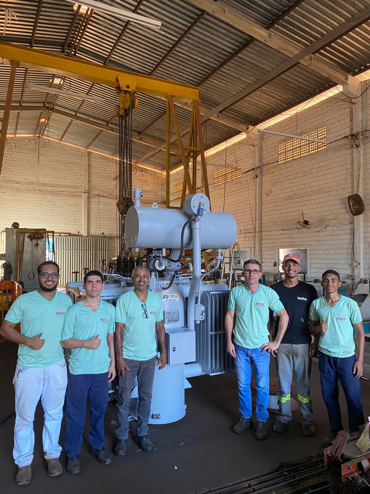 Equipe da MCruz Engenharia em frente a um transformador